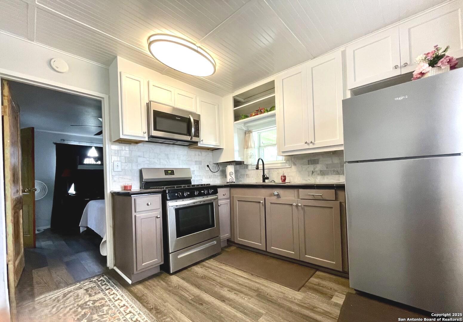 406 Hackberry Street Bandera, TX 78003 - Photo 14 of 34 a kitchen with stainless steel appliances granite countertop a stove a refrigerator and a microwave