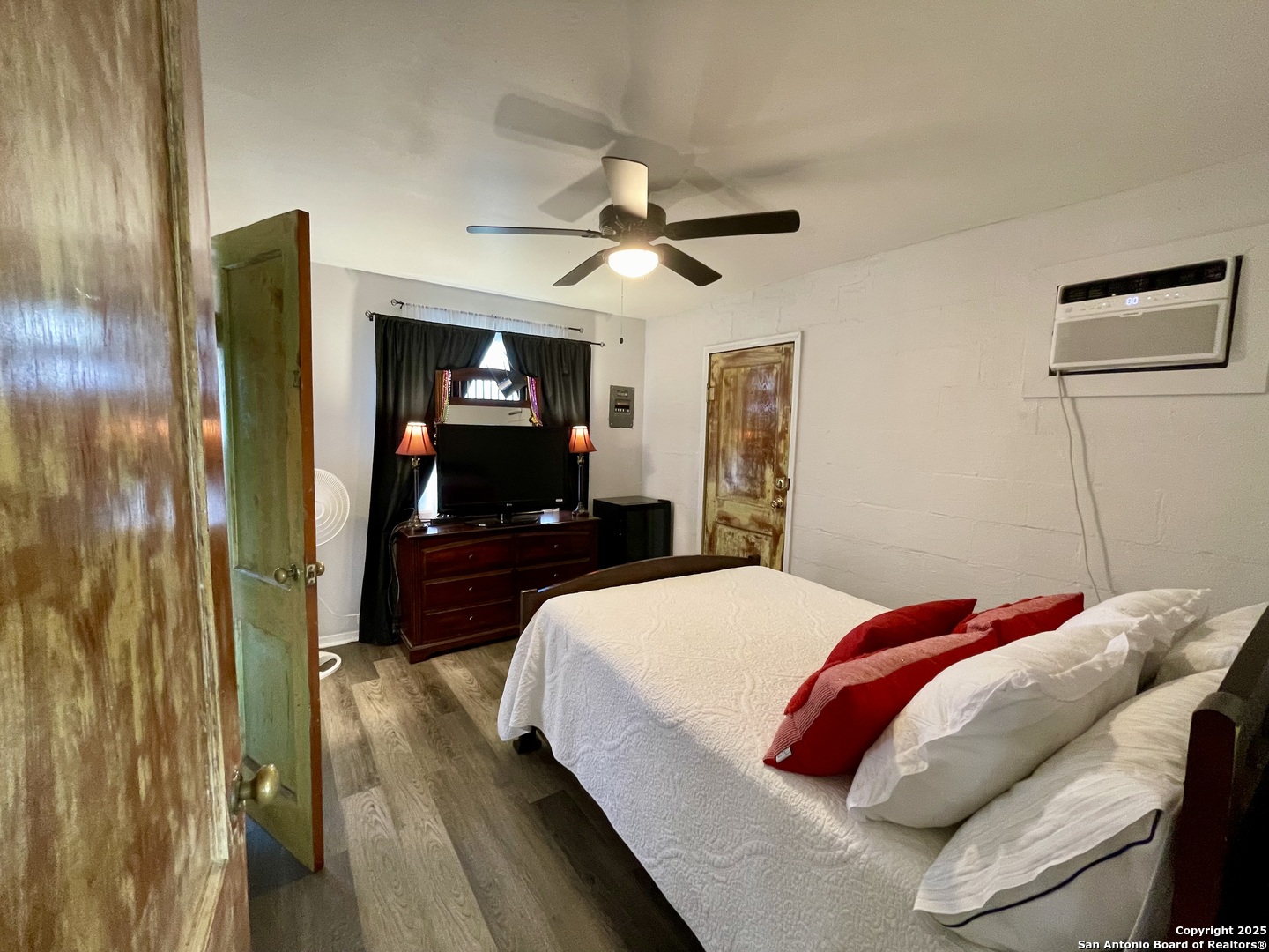 406 Hackberry Street Bandera, TX 78003 - Photo 18 of 34 a bedroom with a bed and a large mirror with a flat tv screen