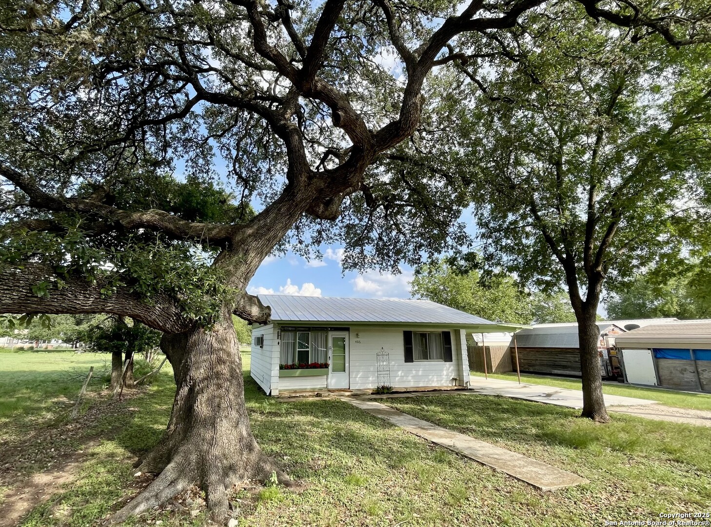 406 Hackberry Street Bandera, TX 78003 - Photo 2 of 34 a front view of a house with garden