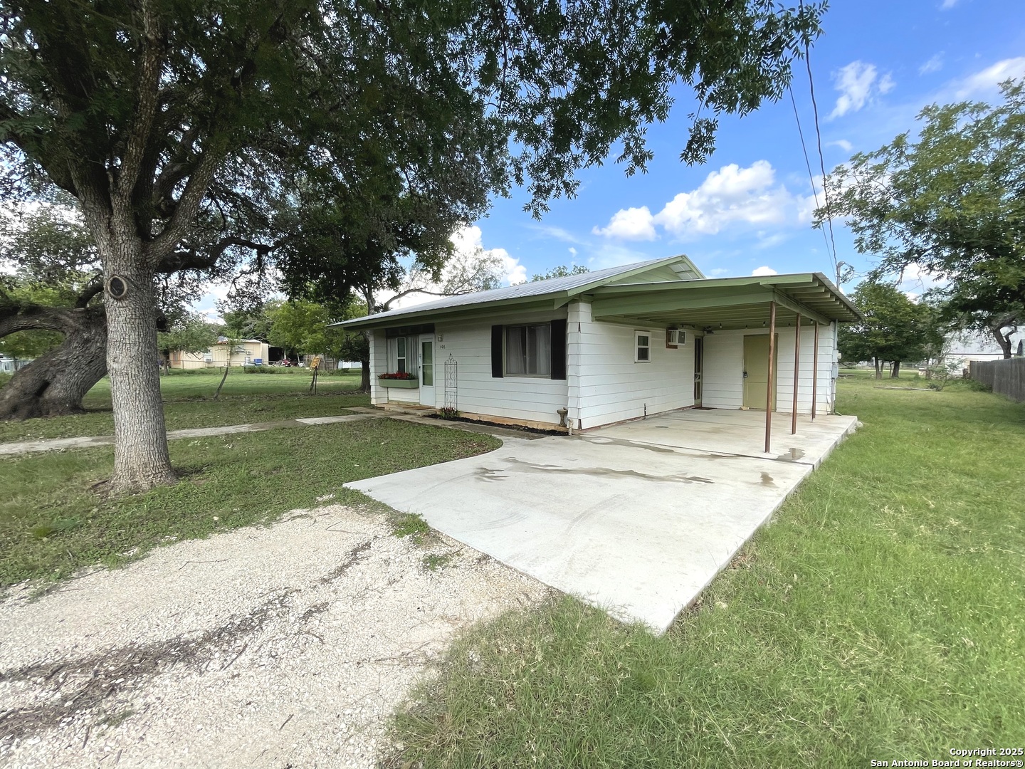 406 Hackberry Street Bandera, TX 78003 - Photo 26 of 34 a view of a white house with a big yard plants and large trees