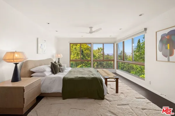 a bedroom with a bed and a large window