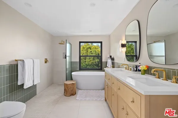 a bathroom with a double vanity sink mirror and toilet