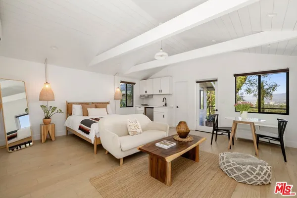 a bedroom with furniture and a large window