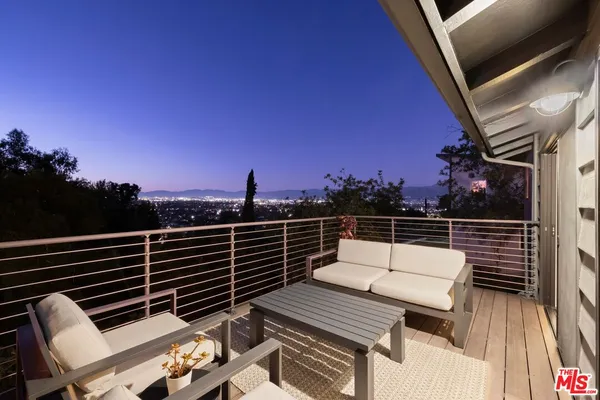 a roof deck with wooden floor and city view