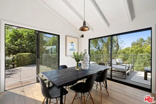 a view of a dining room with furniture large windows and wooden floor