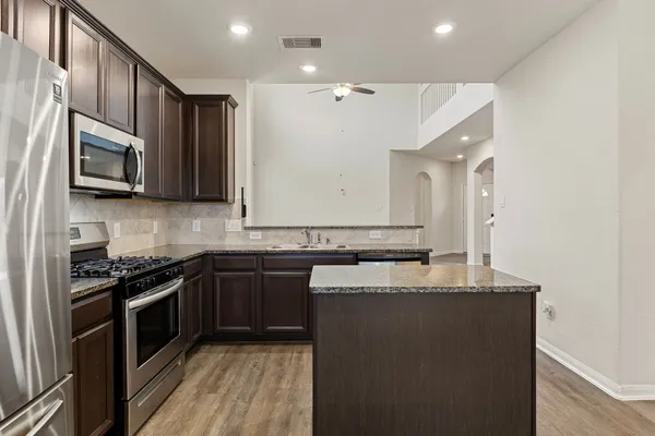 a kitchen with stainless steel appliances a sink stove and microwave