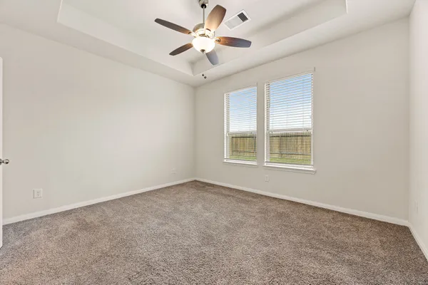 an empty room with chandelier fan and ceiling fan