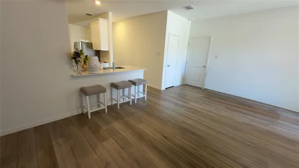 a view of a room with wooden floor table and chairs