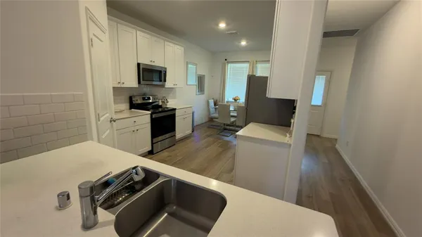 a kitchen with a refrigerator and a stove top oven