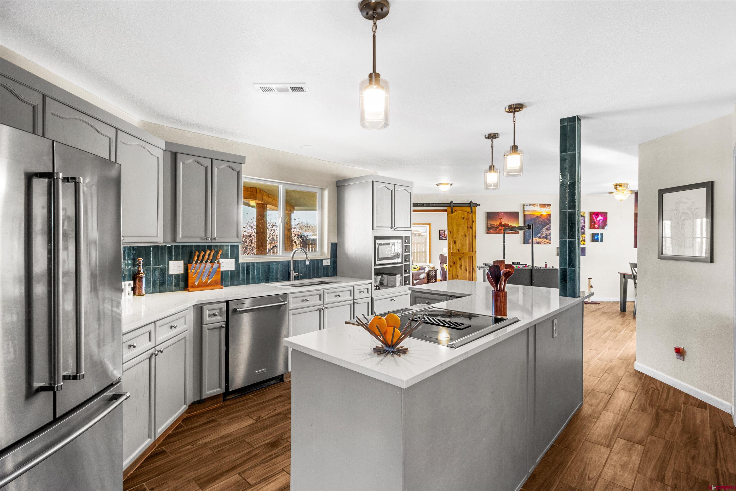 62920 Jeremy Road Montrose, CO 81401 - Photo 5 of 31 a kitchen filled a sink a counter top space stainless steel appliances and cabinets