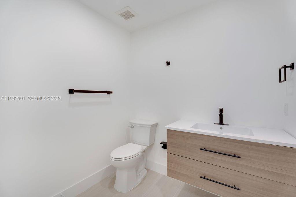 11256 Southwest 90th Lane, Unit 11256 Miami, FL 33176 - Photo 15 of 36 a bathroom with a toilet a sink and mirror