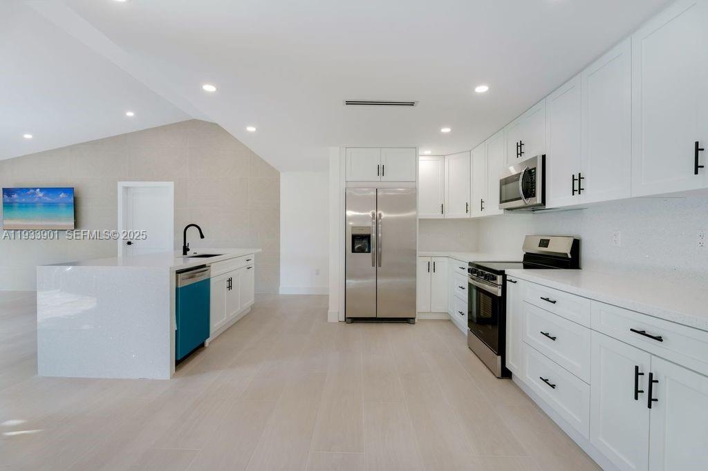 11256 Southwest 90th Lane, Unit 11256 Miami, FL 33176 - Photo 7 of 36 a kitchen with white cabinets and stainless steel appliances