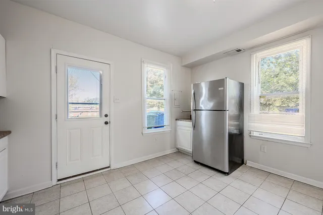 a view of a refrigerator in kitchen and a window