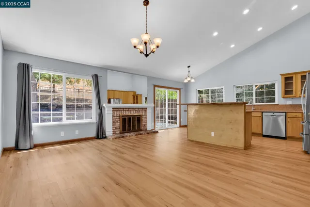 a view of a livingroom with a fireplace wooden floor and windows