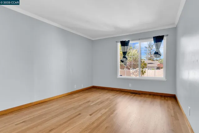 a view of a room with wooden floor and window
