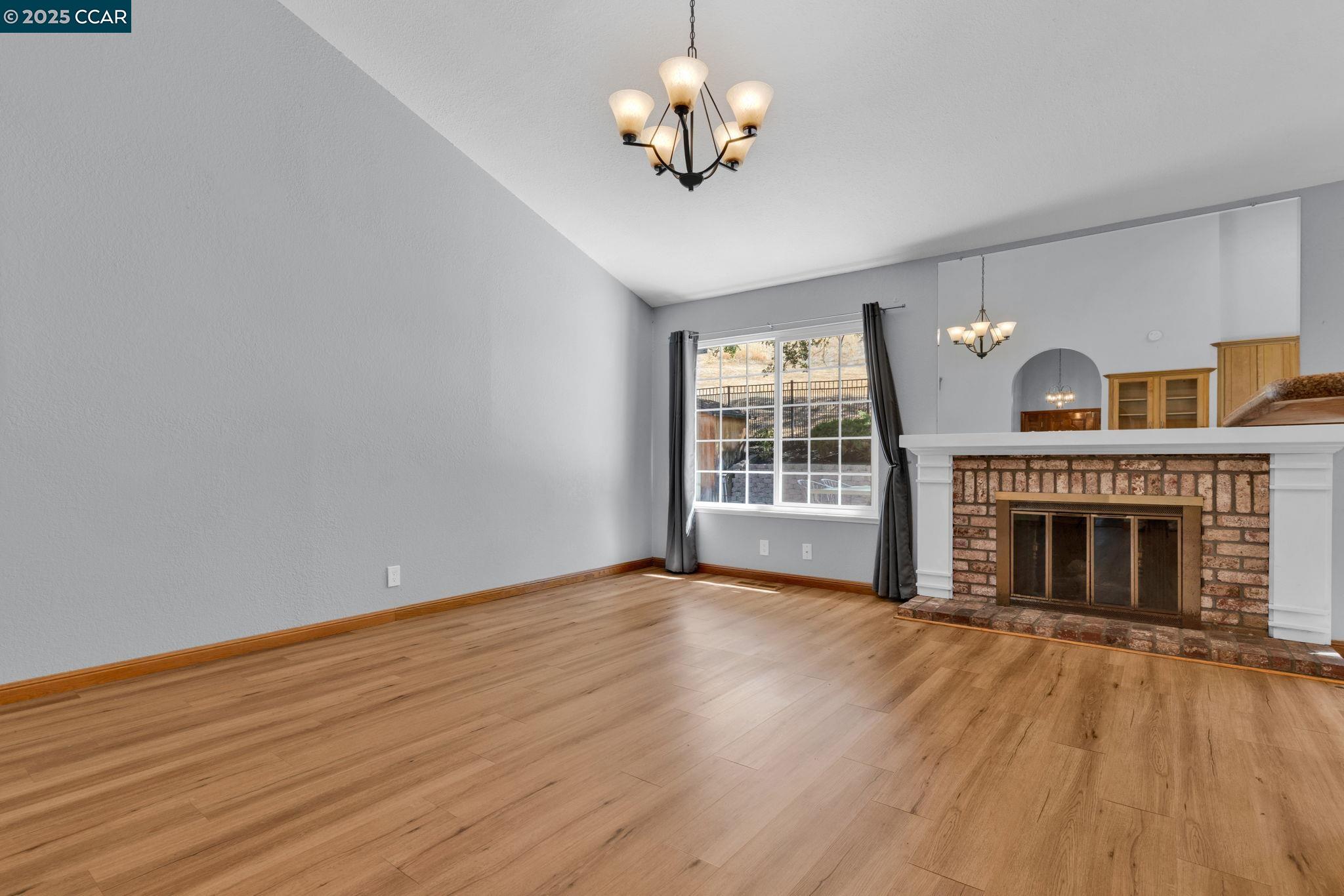 920 Palmer Road Walnut Creek, CA 94596 - Photo 41 of 47 a view of an empty room with wooden floor fireplace and a window