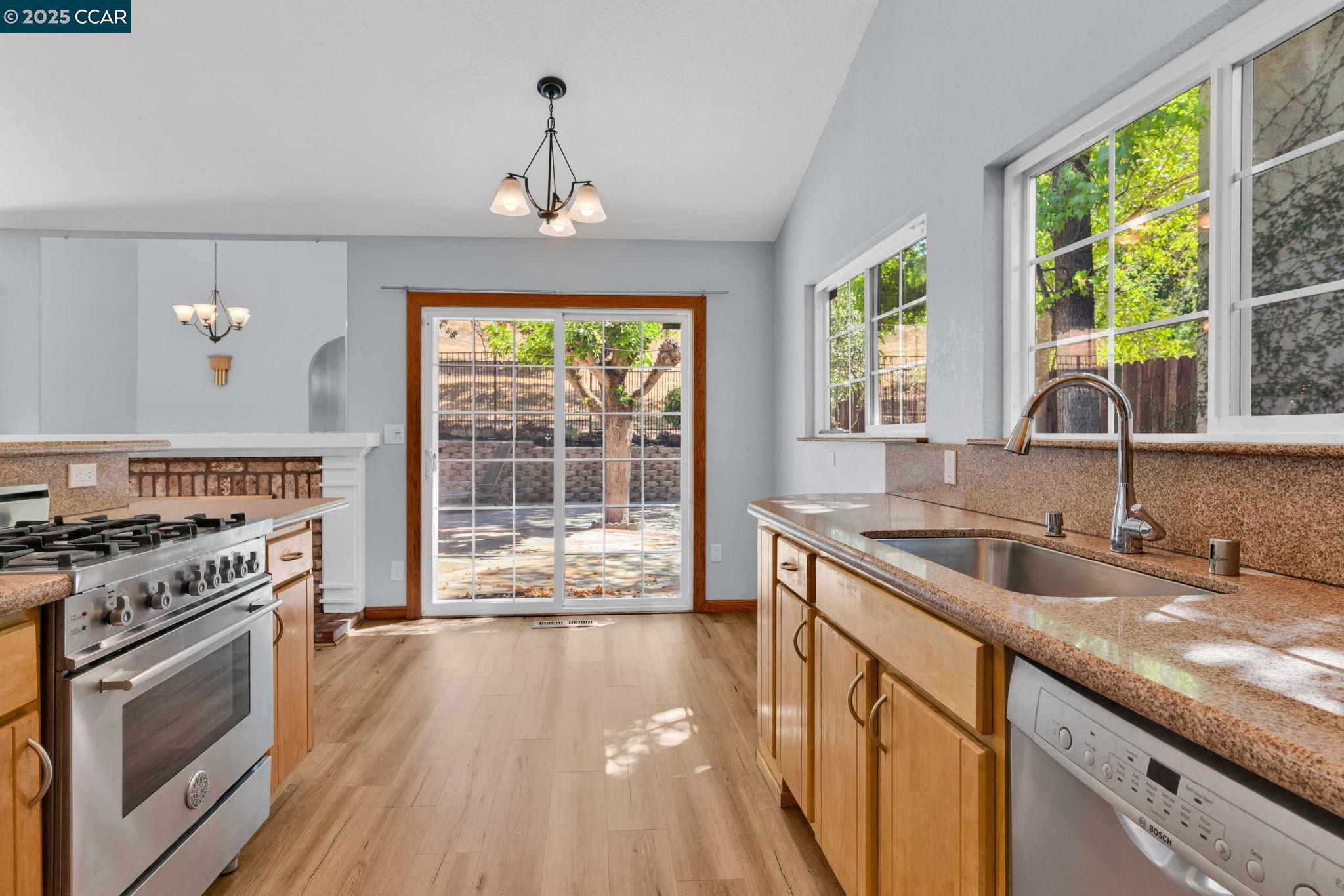 920 Palmer Road Walnut Creek, CA 94596 - Photo 5 of 47 a kitchen with a stove a sink and a wooden floor