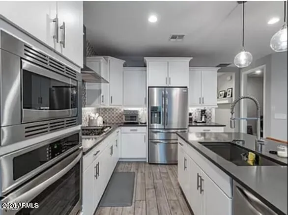 a kitchen with a sink stainless steel appliances and cabinets