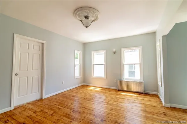 a view of a room with wooden floor and windows