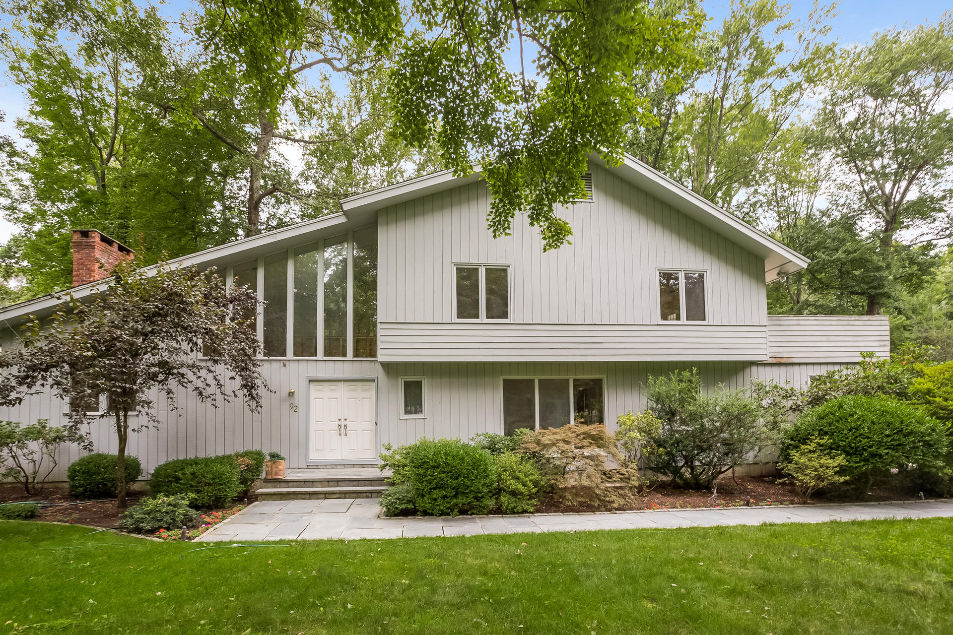 92 Rolling Ridge Road Stamford, CT 06903 - Photo 2 of 34 a front view of a house with a yard and potted plants