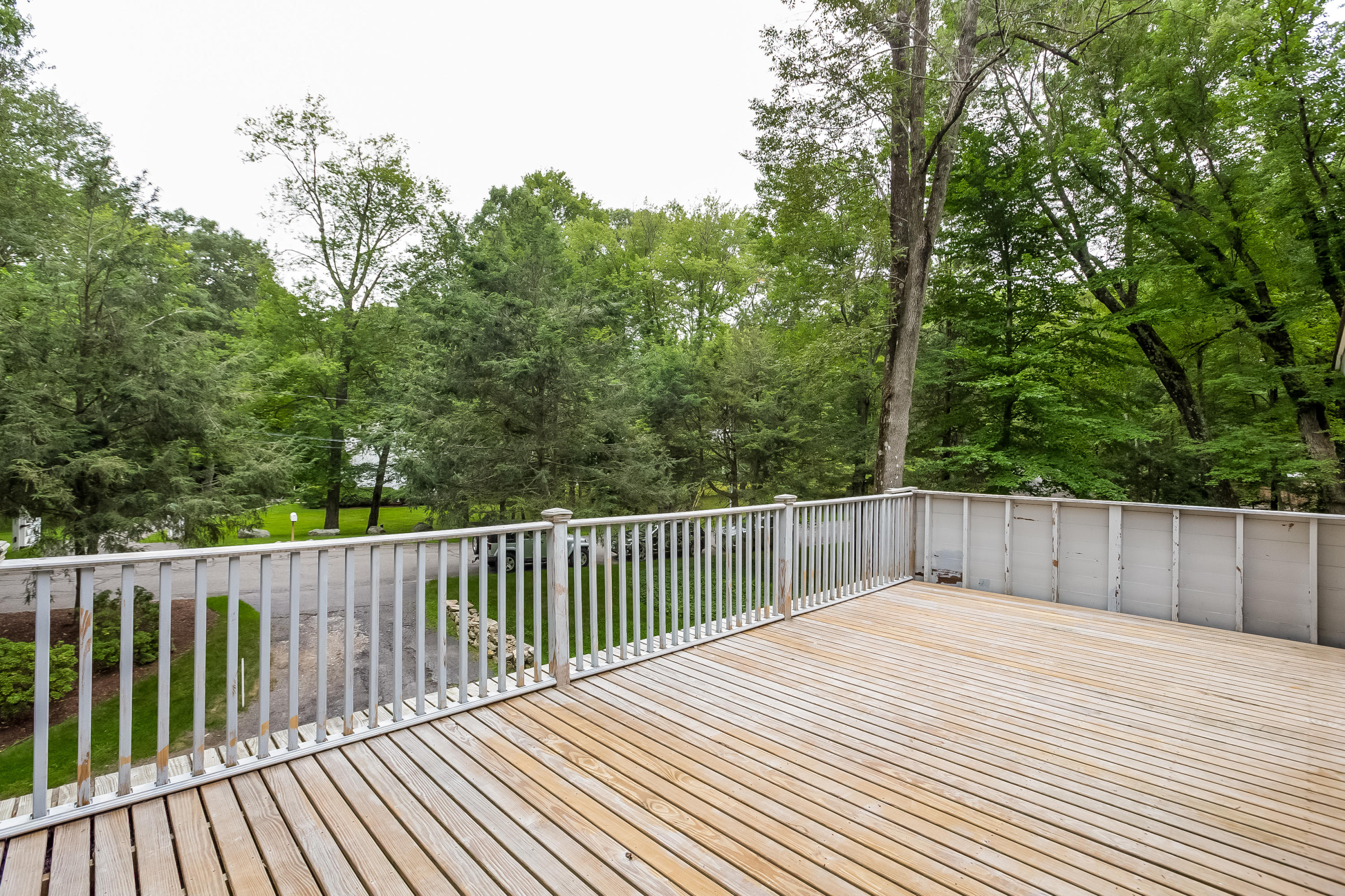 92 Rolling Ridge Road Stamford, CT 06903 - Photo 22 of 34 a balcony with wooden floor and trees in the back