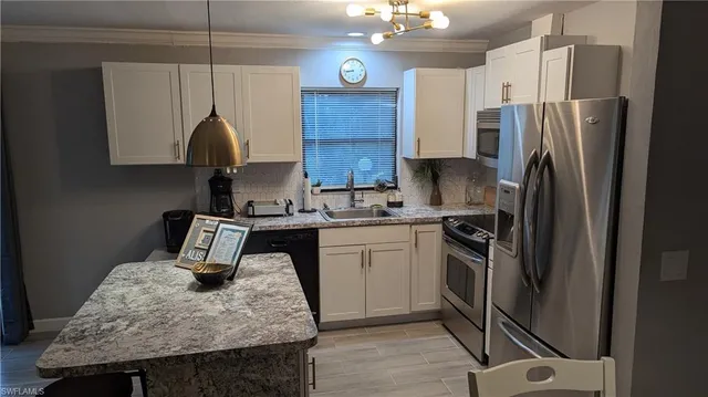 a kitchen with stainless steel appliances granite countertop a sink refrigerator and microwave