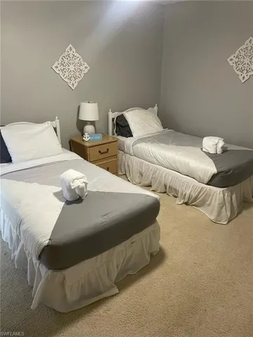 a bedroom with two beds and a lamp