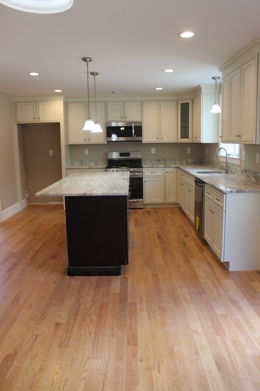 179 Groton Road Chelmsford, MA 01863 - Photo 4 of 19 a large kitchen with stainless steel appliances granite countertop a stove a sink and a refrigerator