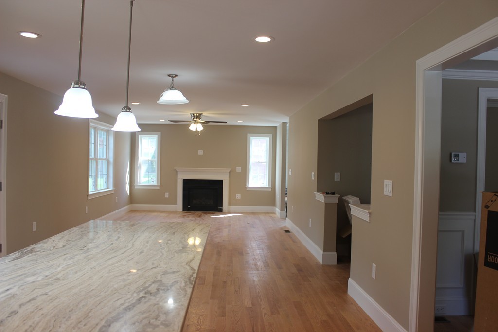 179 Groton Road Chelmsford, MA 01863 - Photo 5 of 19 a view of a livingroom with a fireplace a chandelier and wooden floor