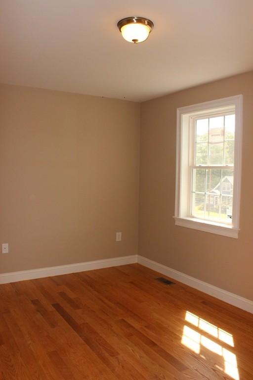 179 Groton Road Chelmsford, MA 01863 - Photo 8 of 19 a view of an empty room with wooden floor and a window