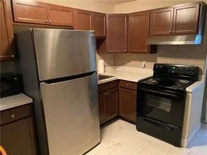 a white refrigerator freezer and a stove sitting inside of a kitchen