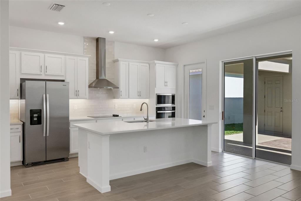 13037 Serene Glade Road Winter Garden, FL 34787 - Photo 17 of 62 a kitchen with stainless steel appliances a refrigerator and a stove