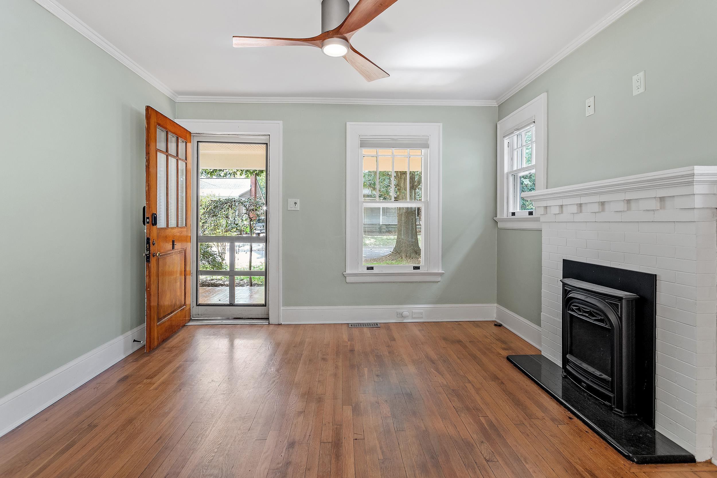 527 Euclid Street Raleigh, NC 27604 - Photo 8 of 27 an empty room with wooden floor fireplace and windows