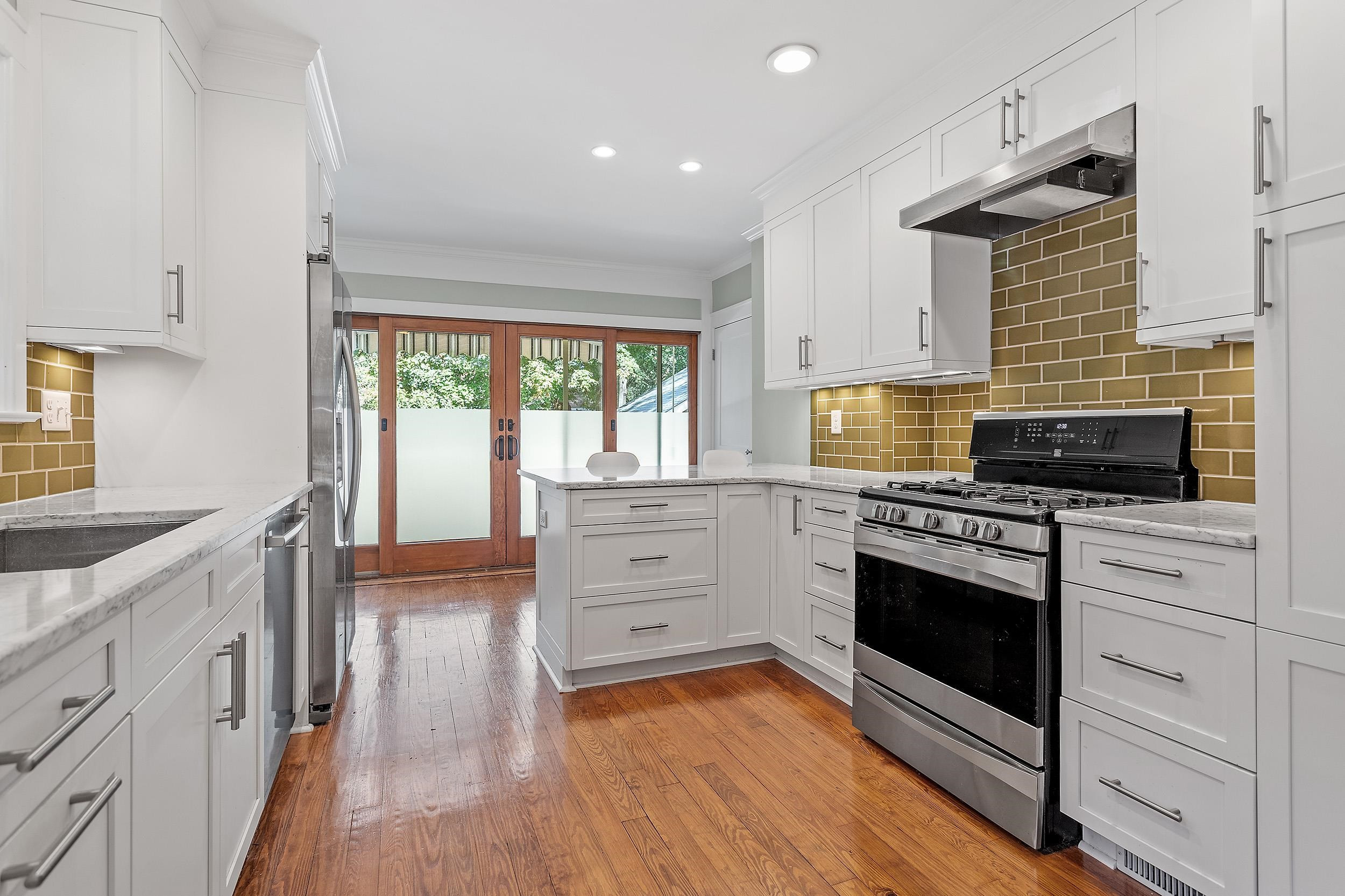 527 Euclid Street Raleigh, NC 27604 - Photo 9 of 27 a kitchen with stainless steel appliances white cabinets and a wooden floor