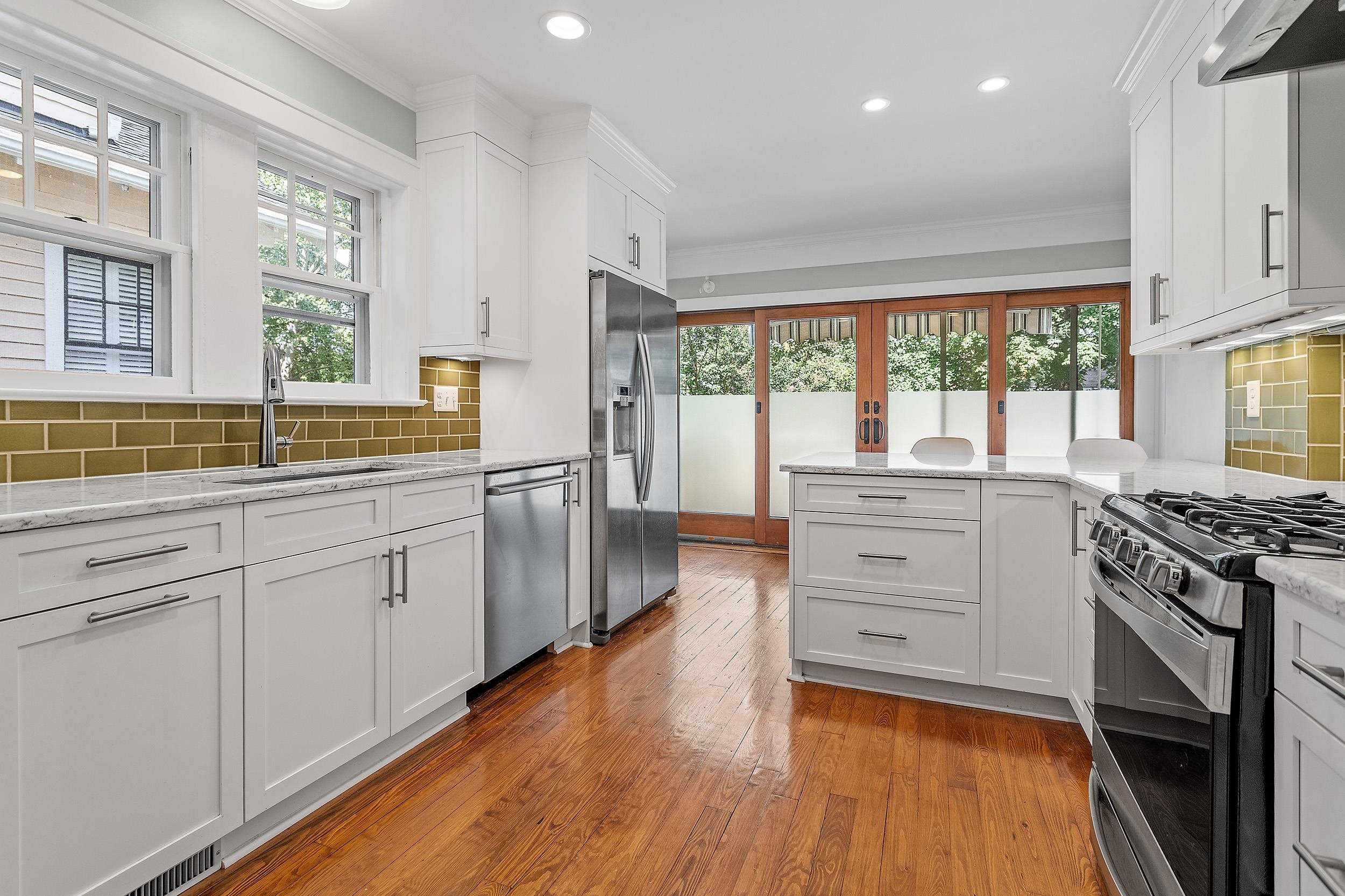 527 Euclid Street Raleigh, NC 27604 - Photo 10 of 27 a kitchen with a stove a sink and white cabinets with wooden floor