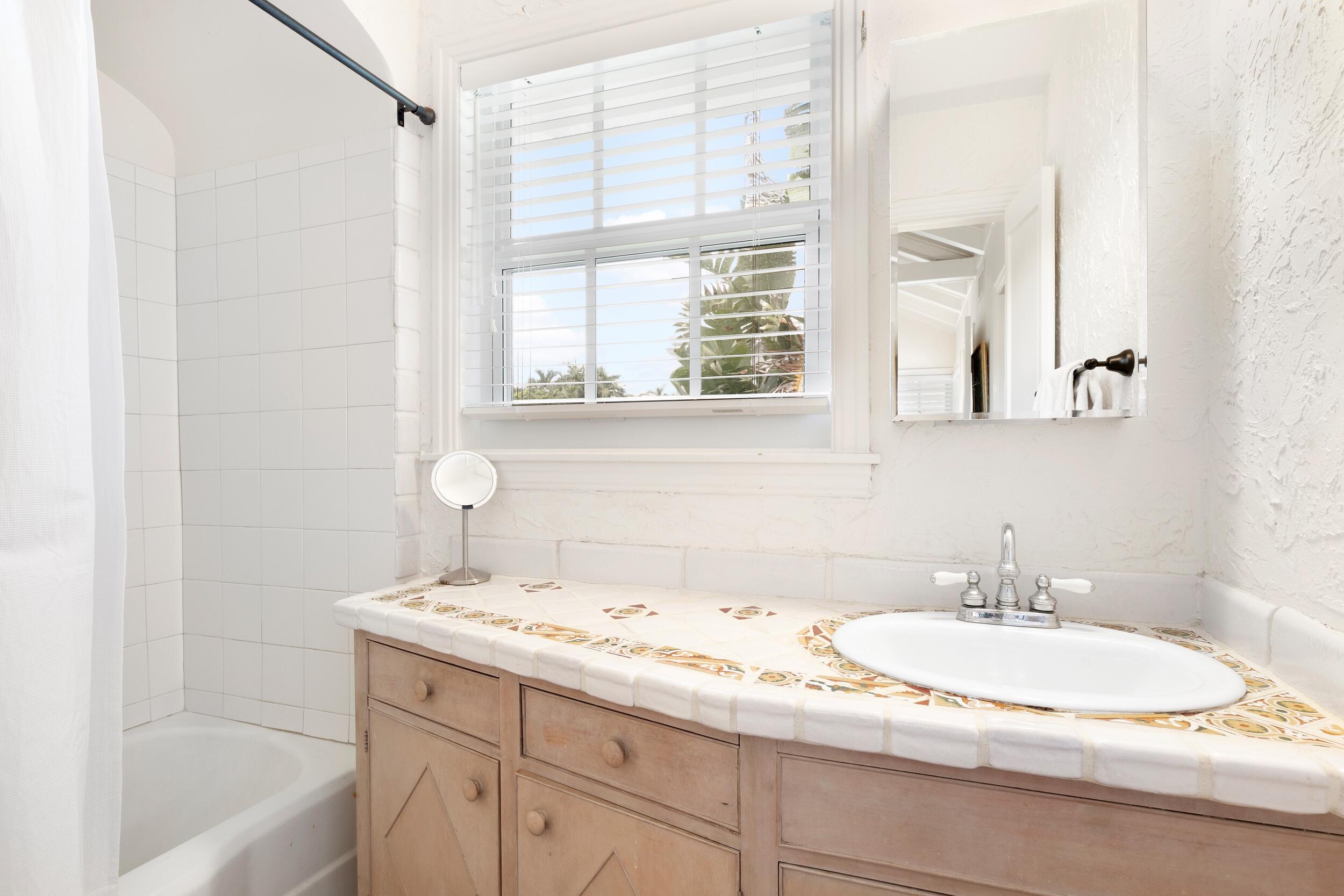 285 Orange Grove Road Palm Beach, FL 33480 - Photo 24 of 29 a bathroom with a granite countertop sink and a bathtub
