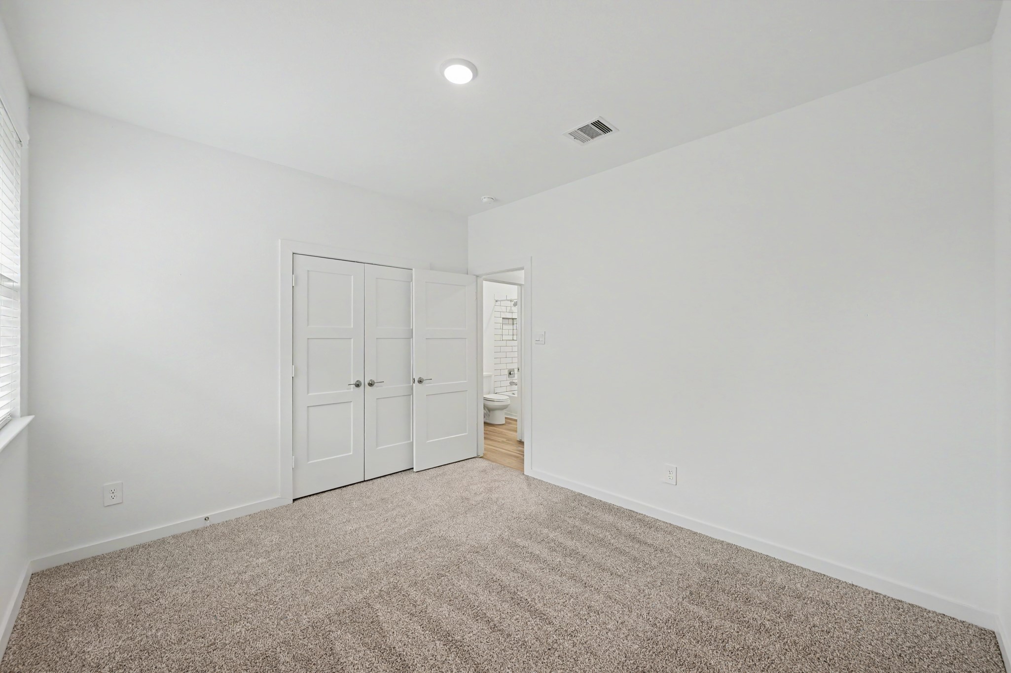 14162 Primrose Ridge Lane Conroe, TX 77384 - Photo 43 of 48 Spacious, light-filled bedroom with plush carpeting, double closet doors, and an en-suite bathroom for added convenience.