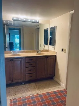 a bathroom with a granite countertop sink and a mirror