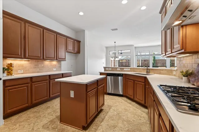 a kitchen with kitchen island granite countertop a sink stove and refrigerator