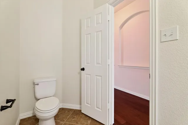 an empty room with wooden floor chandelier fan and windows