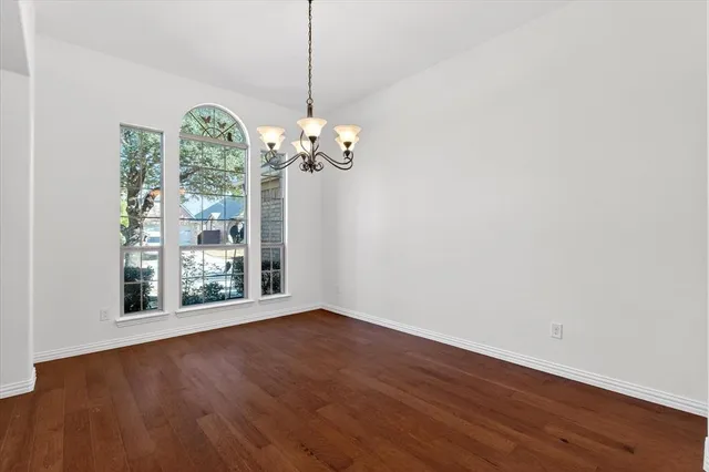 a view of a room with wooden floor chandelier and entryway