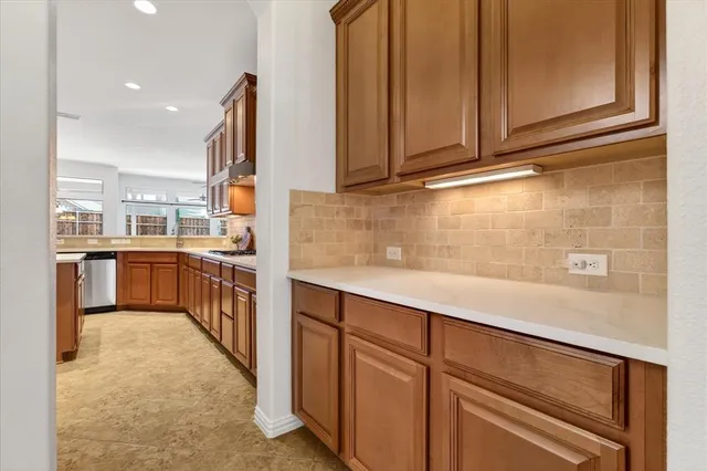 a kitchen with stainless steel appliances granite countertop a stove a sink dishwasher and a refrigerator
