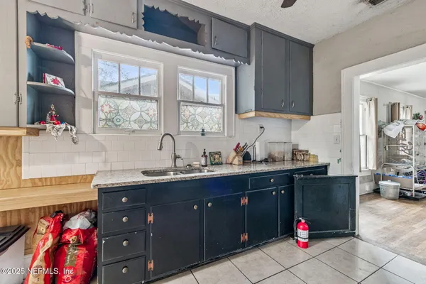 a kitchen with granite countertop a sink stainless steel appliances and cabinets