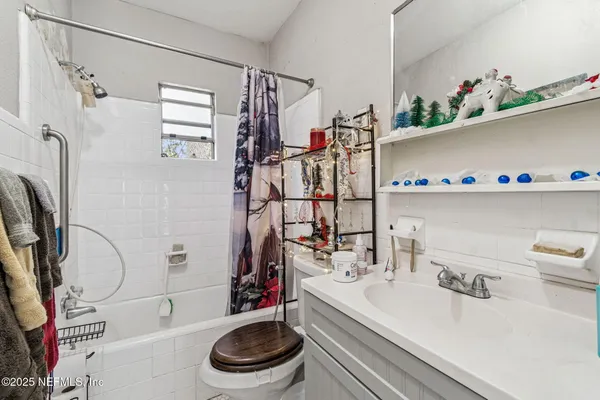 a hallway with white cabinets and wooden floor