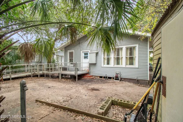 a view of a house with backyard and sitting area