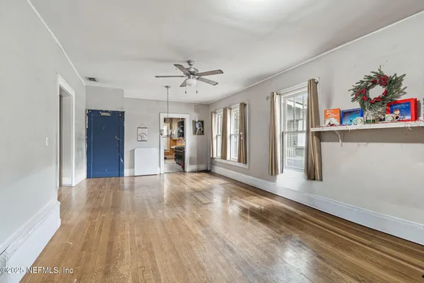 a view of a big room with wooden floor and windows
