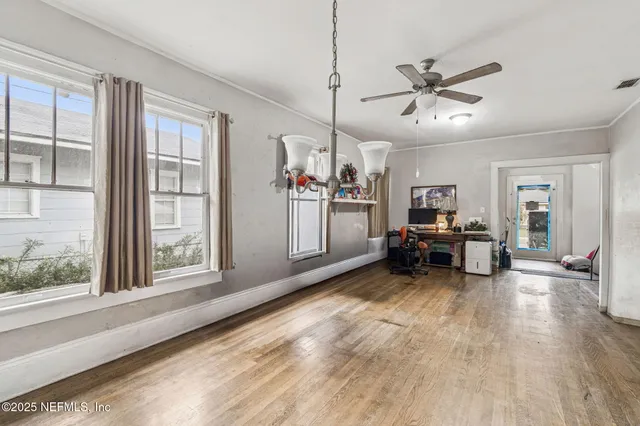 a view of a livingroom with furniture a ceiling fan and windows