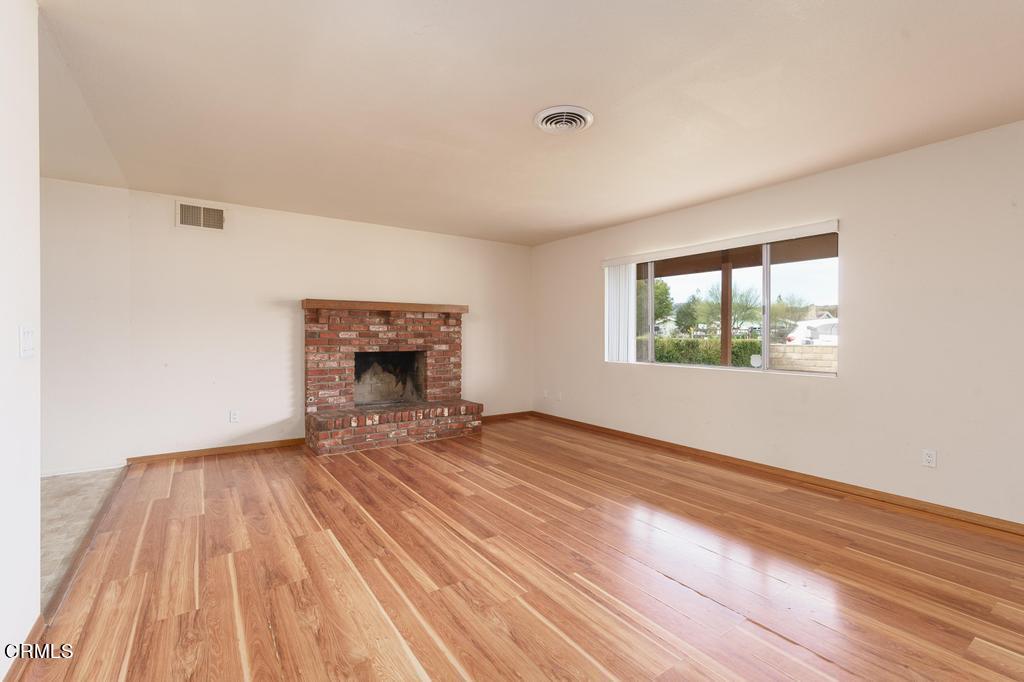 1060 Spring Street Oak View, CA 93022 - Photo 9 of 33 an empty room with wooden floor and windows