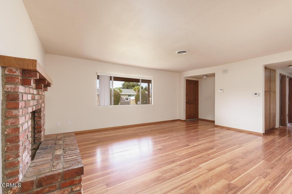 1060 Spring Street Oak View, CA 93022 - Photo 10 of 33 a view of an empty room with wooden floor and a fireplace