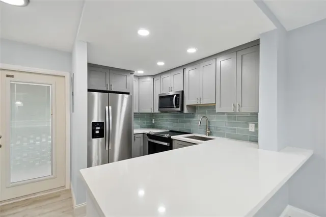 a kitchen with stainless steel appliances a refrigerator and a stove top oven